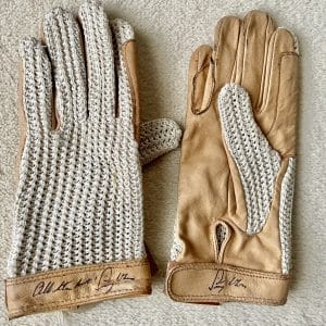 A pair of string backed leather driving gloves signed by the late Sir Stirling Moss